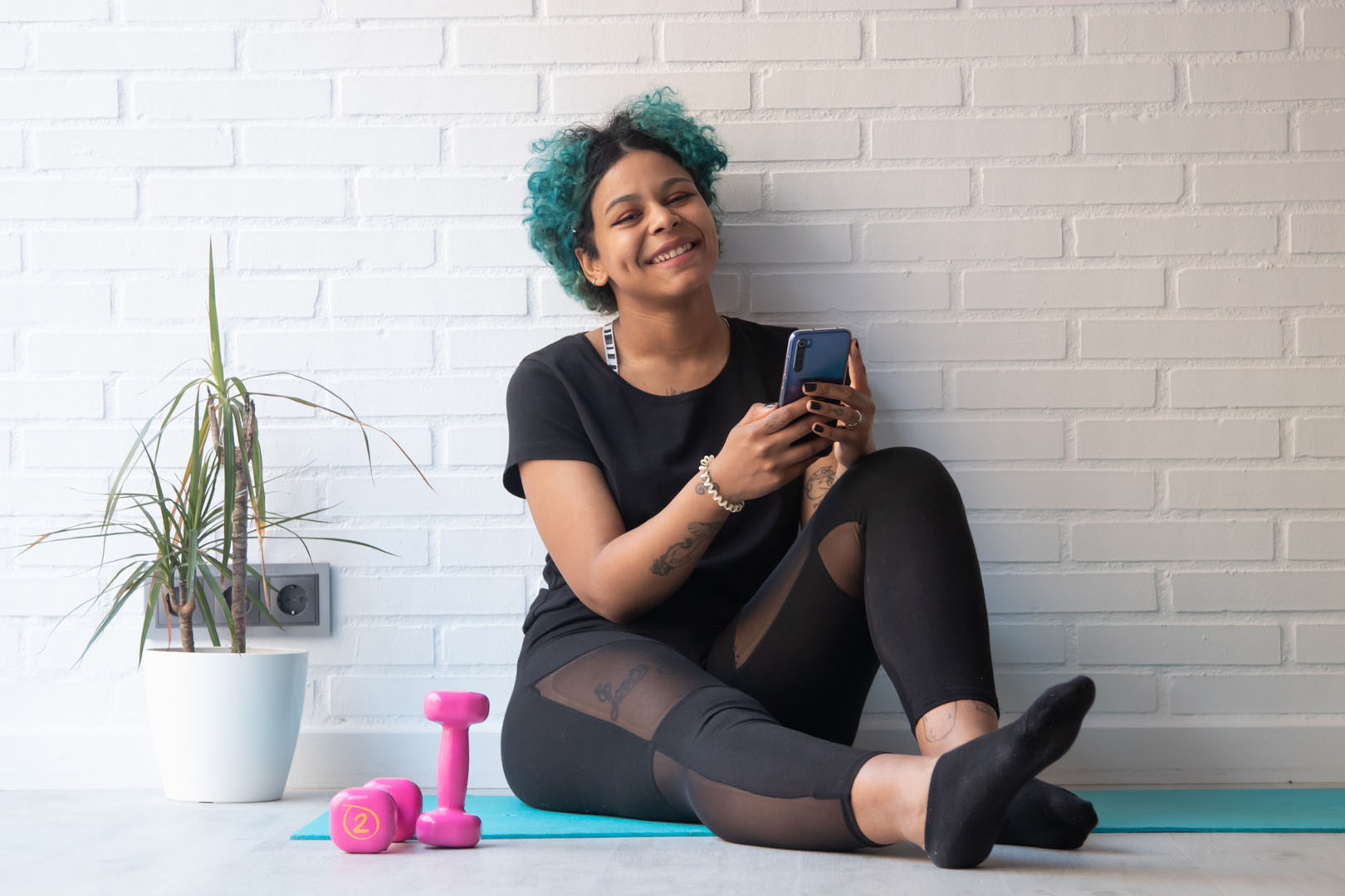girl or woman at home or gym doing sports with mobile phone